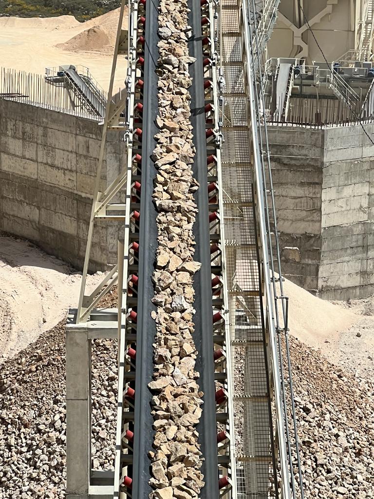 Inclined conveyor carrying crushed rock