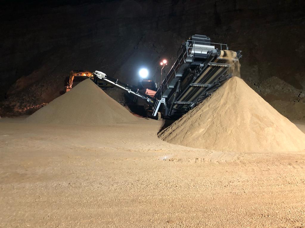 Washed-sand stockpiles under plant lighting